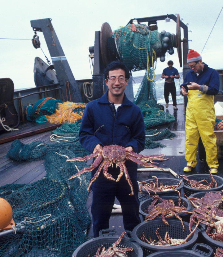 Man standing on the deck of a ship, at sea